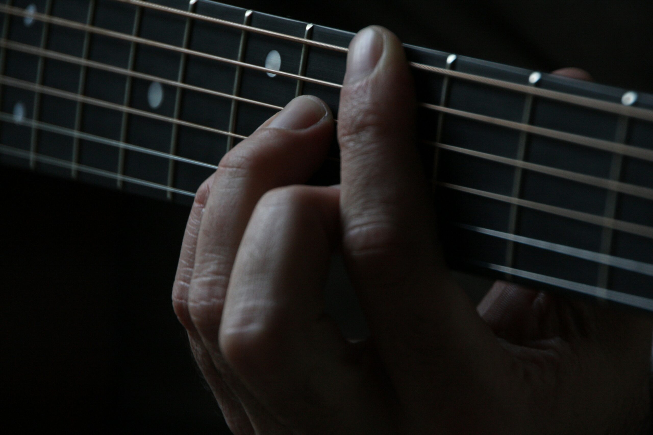 Nahaufnahme einer Hand auf dem Gitarrengriffbrett im Unterricht der Lala Music School Hamburg